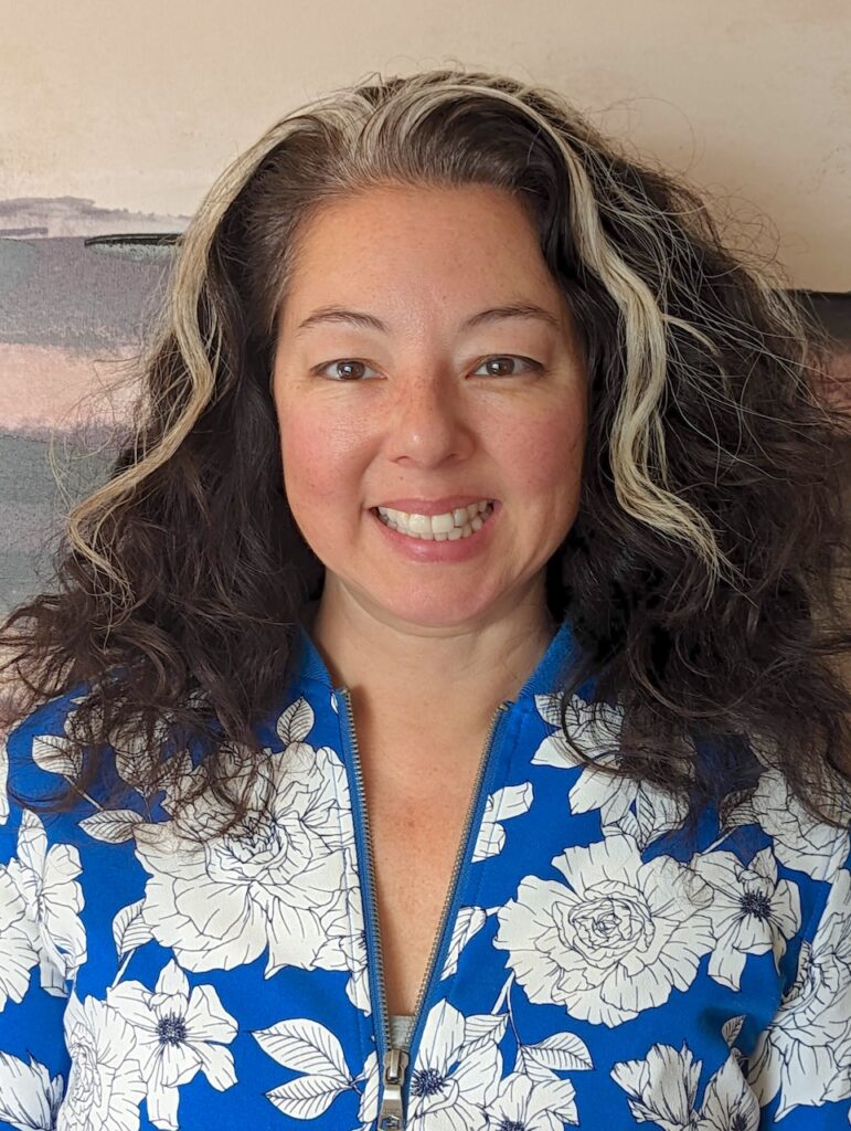 Headshot of Sarah Matsushita. Sarah is smiling, wearing a blue and white top.